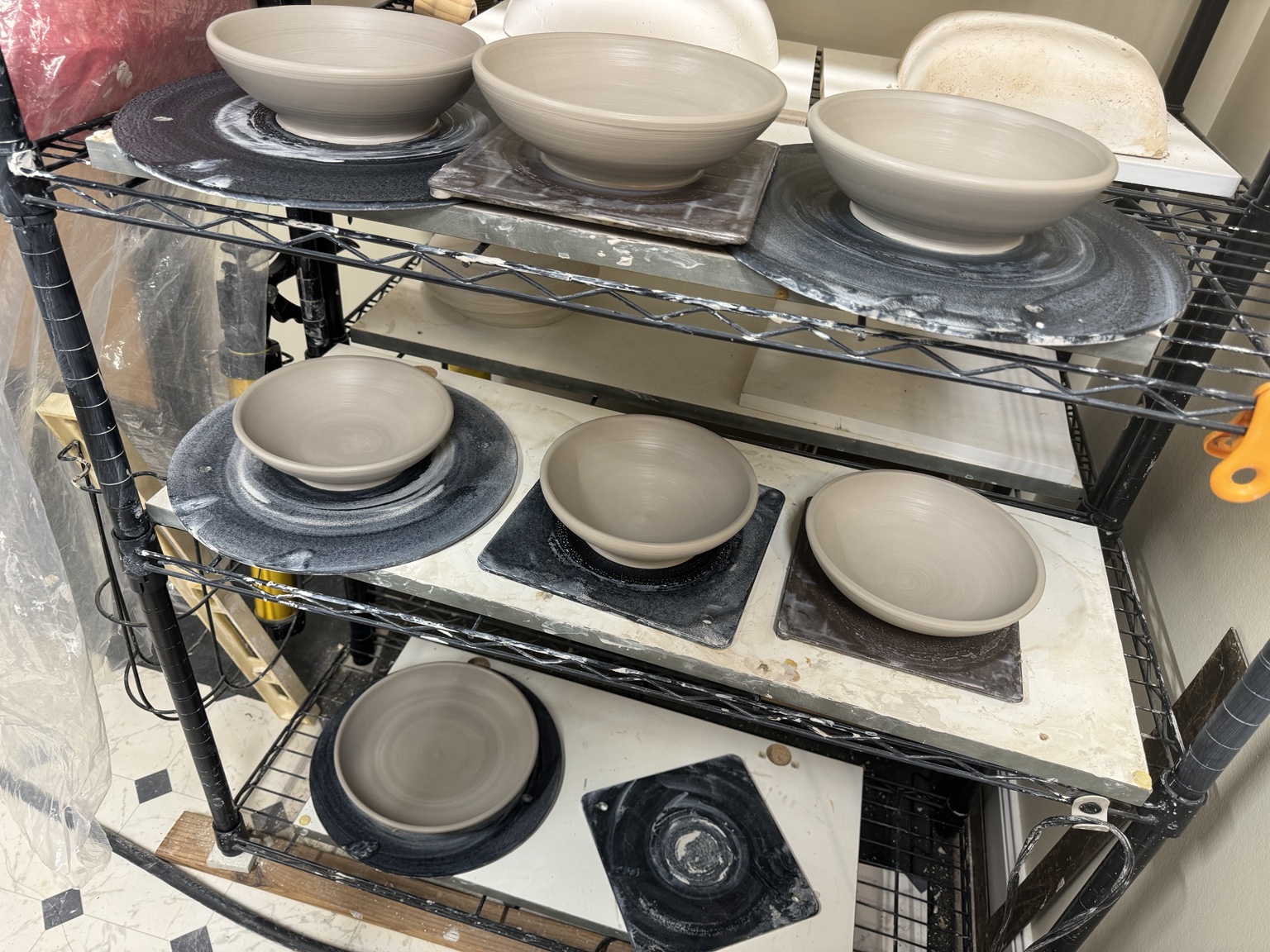 Shelly Flynn's pottery studio with bowls drying on shelves