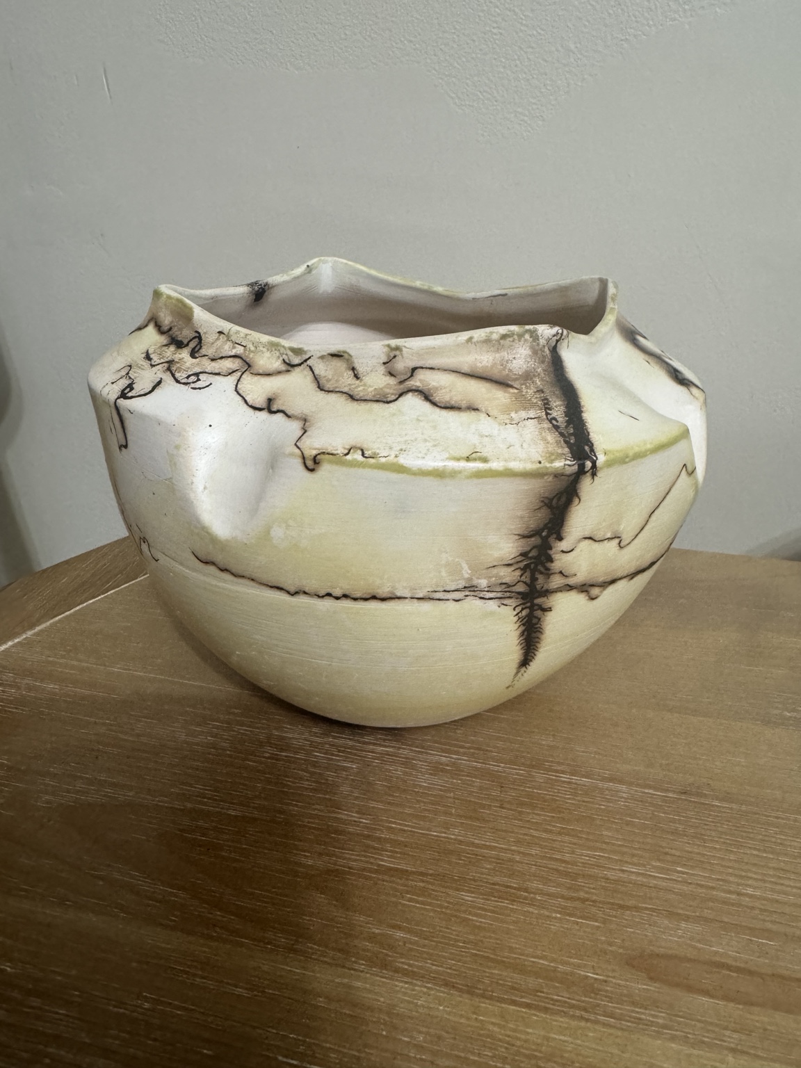 Light ceramic vessel with organic black markings